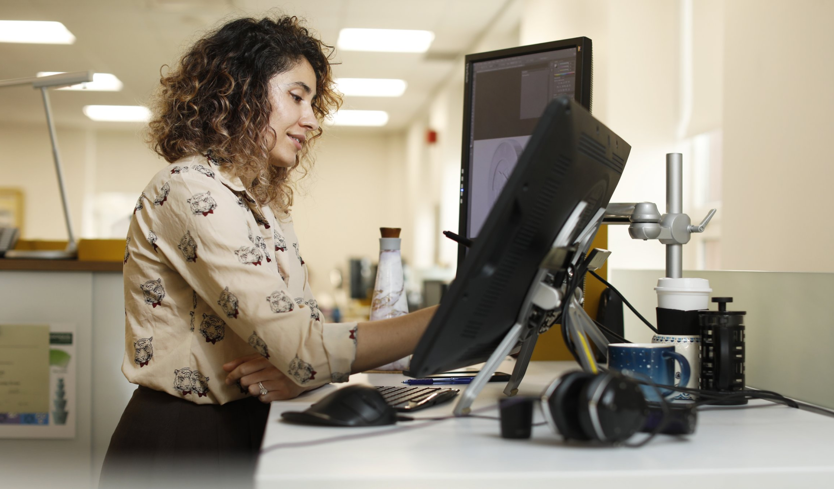 Photo of woman working at her standing desk. 