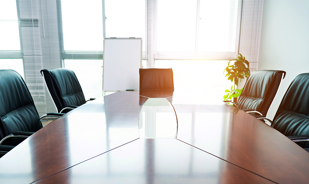 Photo of sun-filled, empty board room. Photo of sun-filled, empty board room.